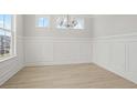 Dining room with light wood floors, white trim, and classic wainscotting at 755 Maynard Ln, Summerville, SC 29486