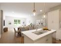 Modern kitchen island with white countertops, sink, and stylish pendant lights at 7621 Indigo Palms Way, Johns Island, SC 29455