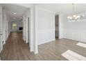 Spacious dining area with light hardwood floors, decorative wall trim, and modern chandelier lighting at 767 Maynard Ln, Summerville, SC 29486