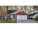 Traditional home with brick accents, attached garage, manicured lawn, and mature trees for curb appeal at 8107 Old London Rd, North Charleston, SC 29406