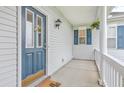 Welcoming front porch featuring a blue door with glass panels and a charming 