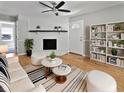 Bright living room with hardwood floors, fireplace, stylish furniture, and a decorative ceiling fan at 103 Sycamore Dr, Summerville, SC 29485