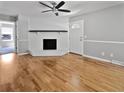 A spacious living room featuring beautiful hardwood floors, a white fireplace, and a ceiling fan at 103 Sycamore Dr, Summerville, SC 29485