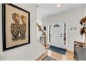 Bright foyer with hardwood floors, white front door with sidelights, and stairway at 118 Congress St # F, Charleston, SC 29403