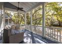 Relaxing porch with comfortable seating and a ceiling fan, offering scenic neighborhood views surrounded by lush trees at 1470 Eutaw Battalion Dr, Charleston, SC 29412