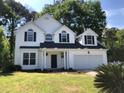 Charming two-story home featuring black shutters, an attached two-car garage, and a well-manicured lawn at 1496 Cypress Pointe Dr, Mount Pleasant, SC 29466