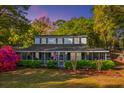 Charming two-story home with a screened-in porch and beautifully landscaped front yard is seen at dusk at 1518 Southwick Dr, Johns Island, SC 29455