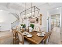 Open dining room with coffered ceilings, modern chandelier, elegant dining set, and staircase access at 152 Seaton St, Summerville, SC 29486