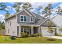 Beautiful two-story home with well-maintained lawn, complemented by mature trees and landscaping at 153 Lucca Dr, Summerville, SC 29486