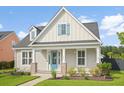 Close up of a charming single-story home with light beige siding, and a bright turquoise front door at 154 Helena Park Dr, Summerville, SC 29486