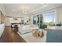 Bright living room featuring modern furniture, a stylish chandelier, and access to a private balcony with scenic views at 155 Wingo Way # 433, Mount Pleasant, SC 29464