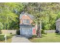 Two-story home with brick and vinyl siding featuring an attached garage and a well-maintained lawn at 1954 Treebark Dr, Charleston, SC 29414