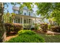Beautiful home exterior showcasing a covered porch and meticulously maintained landscaping with lush greenery at 1977 Pierce St, Charleston, SC 29492