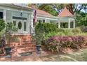 Inviting front entrance with brick steps, manicured landscaping, and quaint architectural details at 210 S Gum St, Summerville, SC 29483