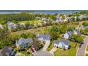 Aerial view of a neighborhood with mature trees, lush green spaces and views of a lake at 2290 Deer Sight Way, Mount Pleasant, SC 29466