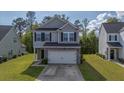Charming two-story home with stone accents, well-maintained lawn, and an attached two-car garage at 234 Daniels Creek Cir, Goose Creek, SC 29445