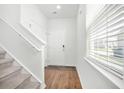 Bright foyer with hardwood floors, staircase, and a view of the front door with security features at 234 Daniels Creek Cir, Goose Creek, SC 29445