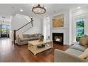 Inviting living room featuring a fireplace, hardwood floors, and staircase, providing a relaxing living space at 2405 Louisville St, Charleston, SC 29492
