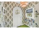 Foyer features patterned wallpaper, green floor tile and arched front door at 27 Stocker Dr, Charleston, SC 29407
