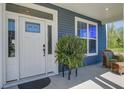 Inviting front porch features a cozy sitting area and a well-decorated front door with a side window at 2880 Cavalcade Cir, Johns Island, SC 29455
