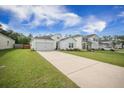 Wide view of a house with long driveway, landscaped lawn and adjacent property in a suburban neighborhood at 293 Firewheel Ct, Summerville, SC 29486