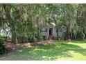 Charming home nestled among mature trees, featuring a classic brick stairway entrance and lush lawn at 3023 Maritime Forest Dr, Johns Island, SC 29455