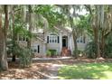 Inviting home with lush greenery, mature trees, and a classic brick stairway entrance at 3023 Maritime Forest Dr, Johns Island, SC 29455