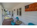 Inviting front porch with cozy seating and American flag decor for a patriotic welcome at 3308 Myrtle St, Edisto Beach, SC 29438
