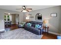 Cozy living room featuring a comfortable leather sofa, ceiling fan, and view into the dining area at 3374 Dunwick Dr, Johns Island, SC 29455
