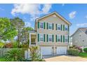 Beautiful home featuring green shutters, a two-car garage, and a quaint porch on a sunny day at 339 Clayton Dr, Charleston, SC 29414