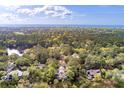 Aerial view showcases a community surrounded by trees and waterfront access and ocean in the distance at 37 Marsh Edge, Kiawah Island, SC 29455