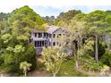 Two-story home nestled among lush trees, featuring dual screened-in porches at 37 Marsh Edge, Kiawah Island, SC 29455