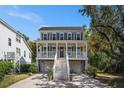 Charming two-story home features a spacious porch, light-colored siding, dark shutters, and well-manicured landscaping at 3717 Tip Ln, Mount Pleasant, SC 29466