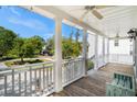 The spacious porch boasts white columns, railings, and ceiling fans, perfect for outdoor living at 3717 Tip Ln, Mount Pleasant, SC 29466