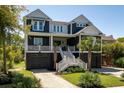 Attractive two-story coastal home with a manicured lawn and inviting entrance at 409 W Indian Ave, Folly Beach, SC 29439