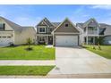 Inviting home featuring a spacious driveway, lush green lawn, and classic architectural details at 476 Foxbank Plantation Blvd, Moncks Corner, SC 29461