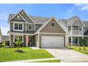 Attractive two-story home with an attached garage, inviting front porch, and manicured lawn at 476 Foxbank Plantation Blvd, Moncks Corner, SC 29461