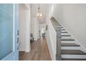 Bright foyer showcasing wood floors, a staircase, and elegant lighting fixtures at 500 W Respite Ln, Summerville, SC 29483