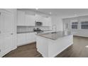 Bright kitchen features white cabinets, stainless steel appliances, and a large kitchen island at 553 Richfield Way, Summerville, SC 29486