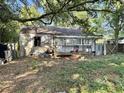 Exterior view of a backyard with overgrown grass, fallen leaves, and a weathered structure at 5901 Sedgefield Dr, Hanahan, SC 29410