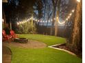 Backyard putting green at twilight with string lights, chairs and firepit at 1002 Blockade Runner Ct, Charleston, SC 29414