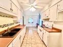 Functional kitchen with white cabinets, tile floors, and a view into the dining area at 1009 Highland Pines Rd, Ladson, SC 29456