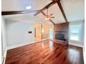 Spacious living room featuring hardwood floors, exposed wood beams, and a brick fireplace at 1009 Highland Pines Rd, Ladson, SC 29456