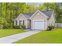 View of charming home with green grass, driveway and a one car garage at 102 Vango Dr, Goose Creek, SC 29445