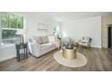 Bright and airy living room with light colored walls, hardwood floors, and comfortable furnishings at 103 Bush Dr, Bonneau, SC 29431