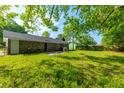 Expansive backyard, ideal for entertaining, featuring a patio area, lush grass, and mature trees at 1104 Margaret Dr, Ladson, SC 29456