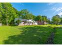 Wide angle shot of the exterior of the property featuring green lawn and brick facade in a neighborhood setting at 1104 Margaret Dr, Ladson, SC 29456