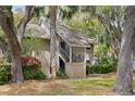 Inviting condo with covered stairwell entrance amidst palm trees and vibrant azalea bushes at 113 High Hammock Villas, Seabrook Island, SC 29455