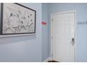 Shot of the light blue hallway with a picture of a frog and a white entry door to the unit at 114 W Arctic Ave # B302, Folly Beach, SC 29439