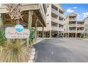 Pier Pointe Villas building with multiple balconies, covered parking and beautifully landscaped grounds at 114 W Arctic Ave # B302, Folly Beach, SC 29439